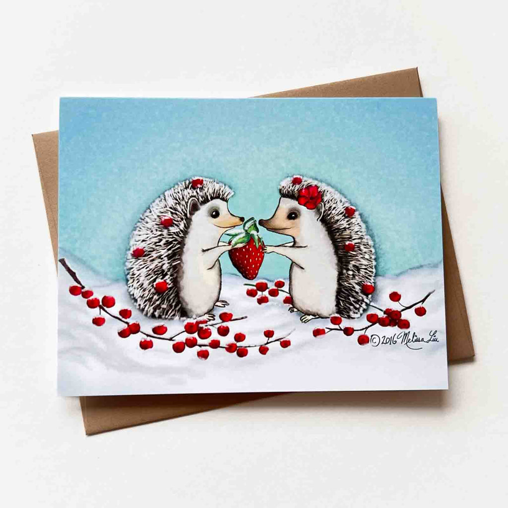 A greeting card showing two hedgehogs sharing a strawberry