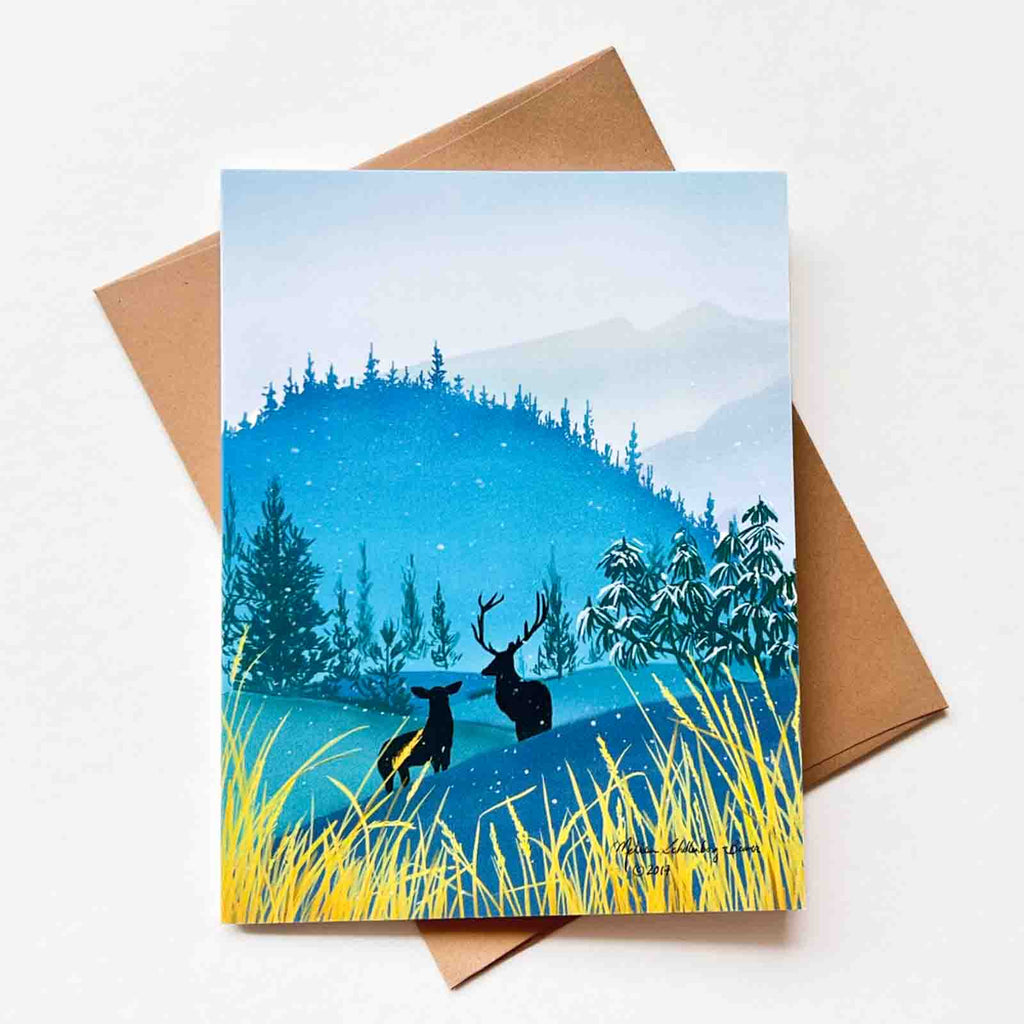 A greeting card of two deers standing in the mountains