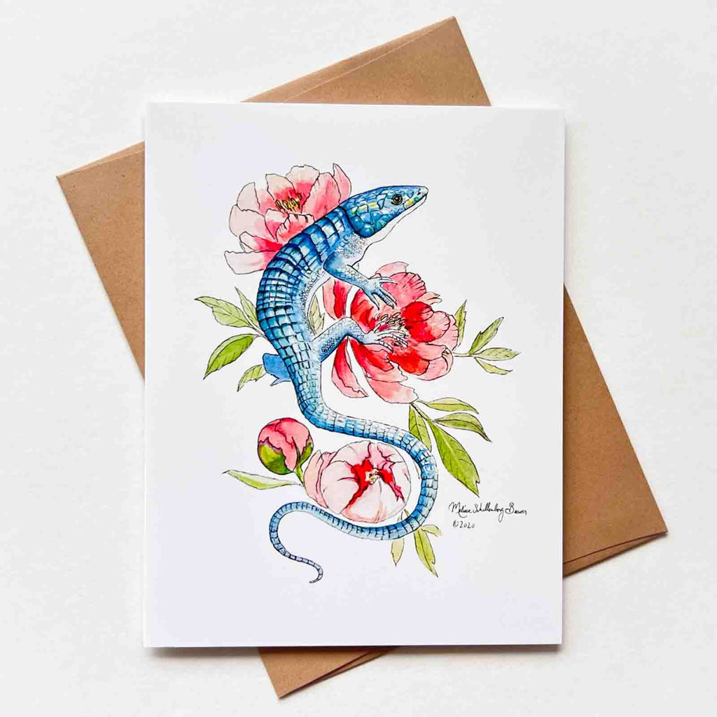 a notecard featuring a blue lizard resting on peony flowers