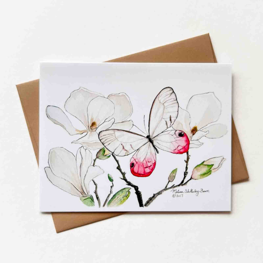 a beautiful notecard featuring a pink and white butterfly resting on magnolia flowers