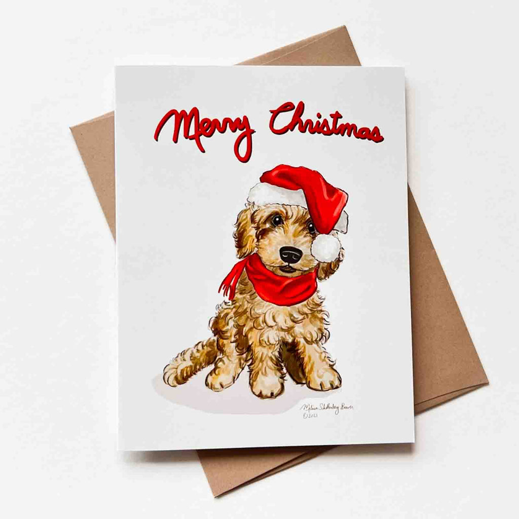 A cute goldendoodle wearing a red Santa hat is featured on this card. Matching brown envelope is shown