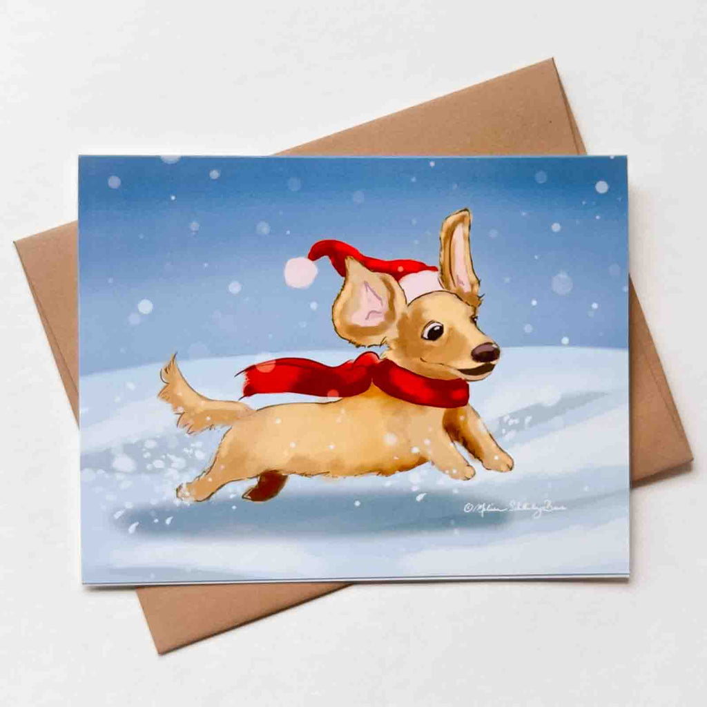 This Christmas card features a happy long haired dachshund dashing through the snow. 