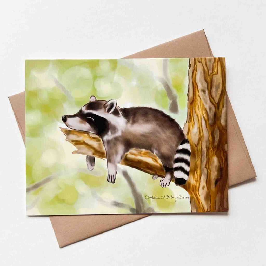 This greeting card features a cute raccoon napping on a tree branch.