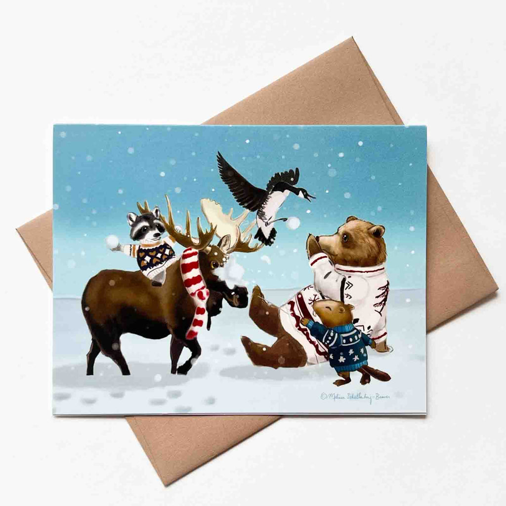 this holiday card features a group of Canadian animals having a snowball fight. A raccoon is riding a moose while chucking a snowball at a big brown bear. A Canada goose is dropping snow balls and a beaver is throwing a snowball back. 