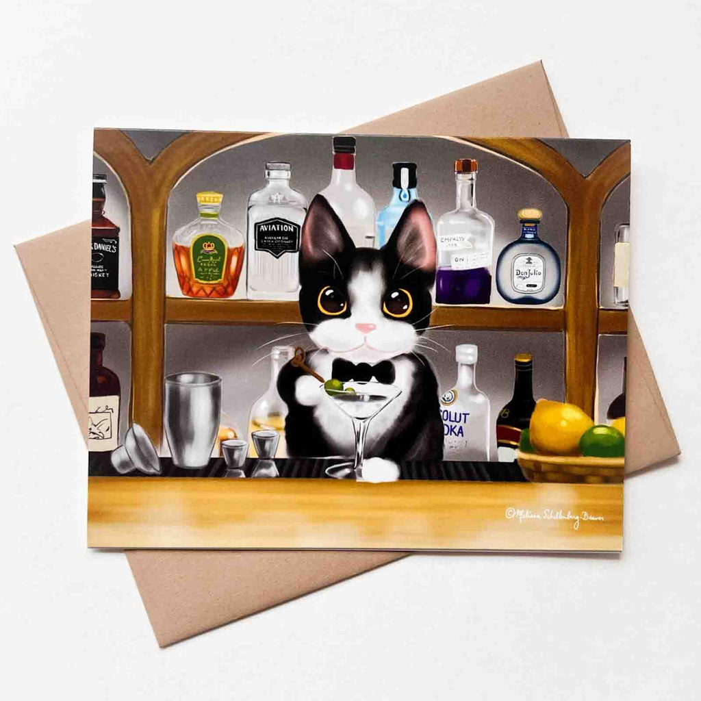 This everyday greeting card features a black and white 'Tuxedo' Cat mixing up a fancy cocktail at the bar. Behind him are shelves full of assorted alcohol. 