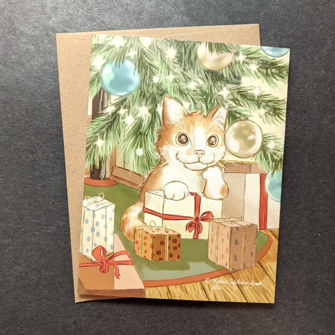 A holiday card featuring an orange cat sitting under a Christmas tree surrounded by presents