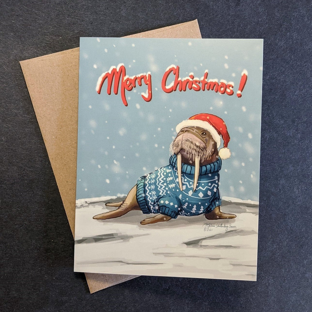 This holiday card features a walrus wearing a Christmas sweater in a snowy background