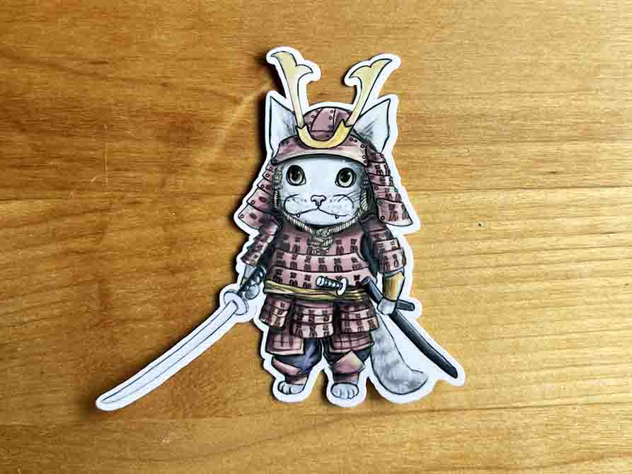 vinyl sticker featuring a stylized cat wearing Japanease Samurai warrior armour, holding a katana